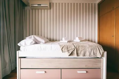 a bed with white sheets and pillows on it at By the Sea II - calmo com piscina e vista mar. in Funchal