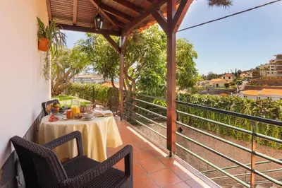 a patio with a table and chairs on a balcony at Pilar House in Funchal