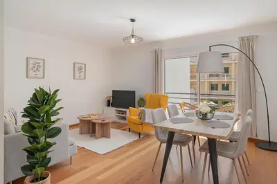 a living room with a dining table and a living room with yellow chairs at Ribeira Brava I by An Island Apart in Ribeira Brava