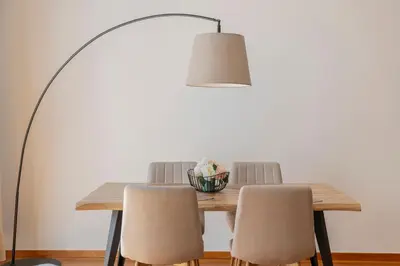a dining table with chairs and a floor lamp at Ribeira Brava I by An Island Apart in Ribeira Brava