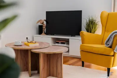 a living room with a tv and a table and a chair at Ribeira Brava I by An Island Apart in Ribeira Brava