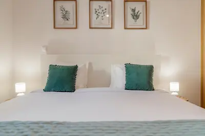 a bedroom with a large bed with green pillows at Ribeira Brava I by An Island Apart in Ribeira Brava