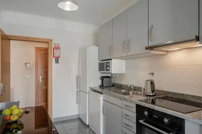 a kitchen with white cabinets and a sink at Ajuda IV by An Island Apart in Funchal