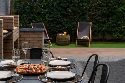 a table with a pizza and glasses of wine at Casa da Amoreira by An Island Apart in Funchal