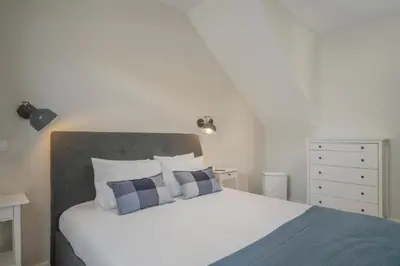 a bedroom with a white bed with blue and white pillows at Casa da Amoreira by An Island Apart in Funchal
