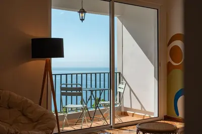 a room with a balcony with a view of the ocean at Melro's Place by Stay Madeira in Ponta do Sol