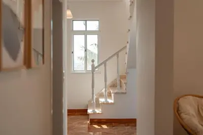 a stairway with a window and a stair case at Melro's Place by Stay Madeira in Ponta do Sol