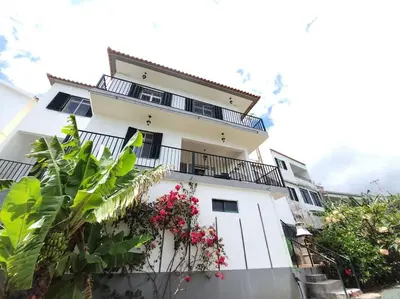 a white building with balconies and flowers on it at Melro's Place by Stay Madeira in Ponta do Sol