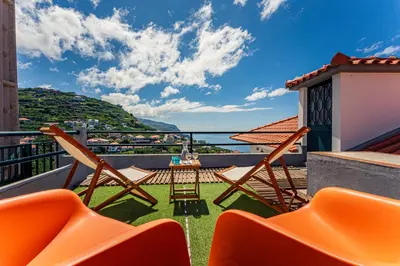 a balcony with chairs and a view of the water at Melro's Place by Stay Madeira in Ponta do Sol