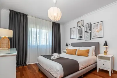 a bedroom with a bed with a teddy bear on it at Ficcus Home in Caniço