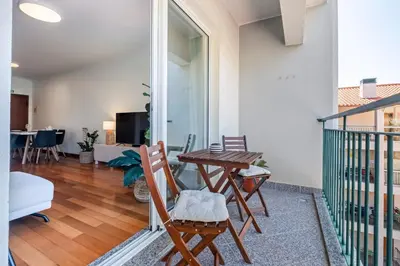 a living room with a table and chairs on a balcony at Ficcus Home in Caniço