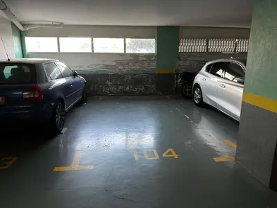 a parking garage with two cars parked in it at Ficcus Home in Caniço