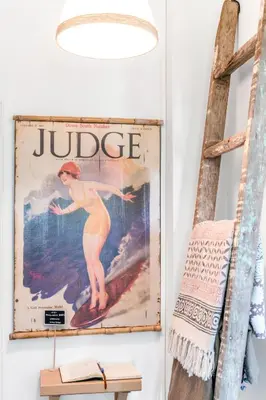 a poster of a woman on a surfboard hanging on a wall at Mola Mola Sagres in Sagres