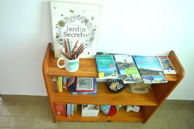 a book shelf with books and a table with books at Mola Mola Sagres in Sagres