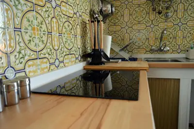 a kitchen with a counter and a wooden table at Mola Mola Sagres in Sagres