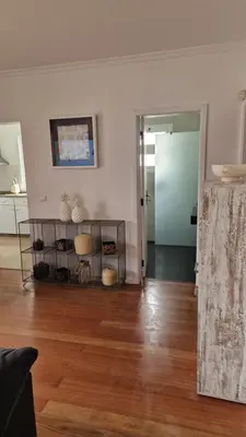 a living room with a hard wood floor and a door at Vila Henrique Country Cottage in Fajã da Ovelha