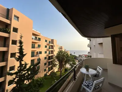 a balcony with a table and chairs and a view of the ocean at Laser Pedra de Abreu in Funchal