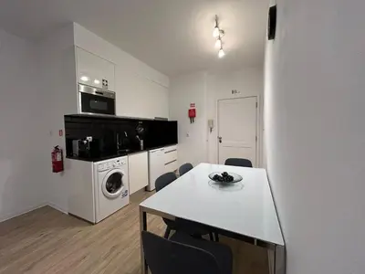 a white kitchen with a table and a microwave at Laser Pedra de Abreu in Funchal