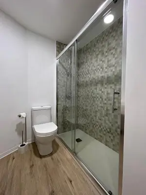 a bathroom with a toilet and a glass shower at Laser Pedra de Abreu in Funchal