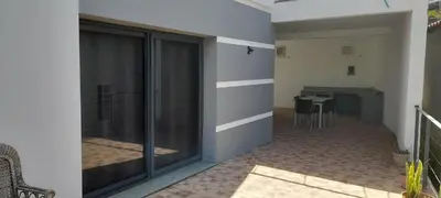 a room with a balcony with a table in the background at Santo Relaxium in Ponta do Sol