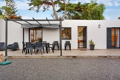 a patio with a table and chairs on a wooden deck at Casa Fonte São João in Vila Baleira