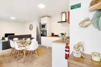 a kitchen and living room with a table and chairs at Casa Fonte São João in Vila Baleira