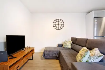 a living room with a couch and a tv at Casa Fonte São João in Vila Baleira