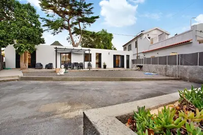 an empty parking lot in front of a white house at Casa Fonte São João in Vila Baleira
