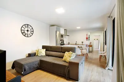 a living room with a couch and a kitchen at Casa Fonte São João in Vila Baleira