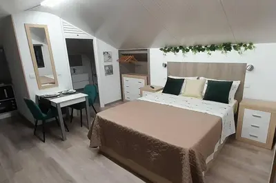 a bedroom with a bed and a table and a desk at SantoSerenus in Ponta do Sol