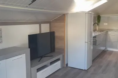a living room with a tv and a kitchen at SantoSerenus in Ponta do Sol