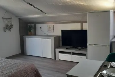 a bedroom with a bed and a flat screen tv at SantoSerenus in Ponta do Sol