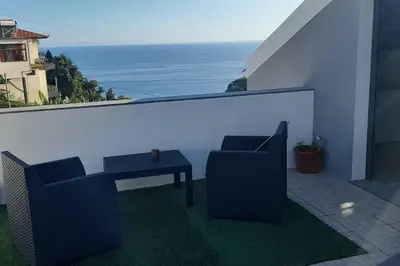 a patio with two chairs and a table on a balcony at SantoSerenus in Ponta do Sol