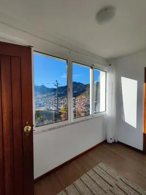 a room with large windows with a view of a city at Machico Terrace in Machico