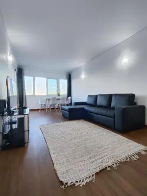 a living room with a blue couch and a rug at Machico Terrace in Machico