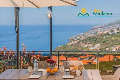 a table with fruit on it with a view of the ocean at OurMadeira - This Side of Paradise in Arco da Calheta