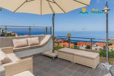 a patio with two couches and an umbrella at OurMadeira - This Side of Paradise in Arco da Calheta