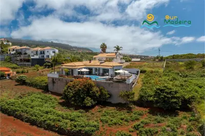 a house with a swimming pool in a field at OurMadeira - This Side of Paradise in Arco da Calheta