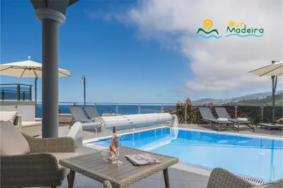 a pool on the roof of a hotel with chairs and a table at OurMadeira - This Side of Paradise in Arco da Calheta