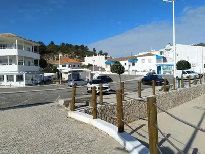 a street with cars parked on the side of a road at Casa Sereia Praia in Salema