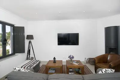 a living room with a couch and a table at Casa Sereia Praia in Salema