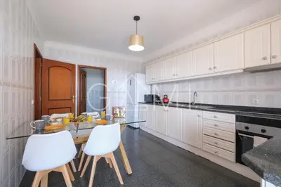 a kitchen with white cabinets and a table and chairs at Casa Vista Mar by GALMI in Calheta