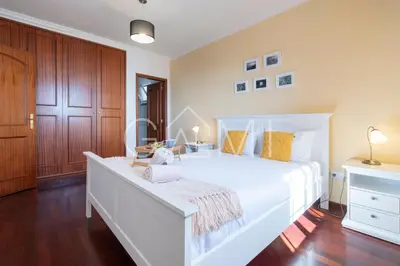 a white bedroom with a large white bed and wooden floors at Casa Vista Mar by GALMI in Calheta