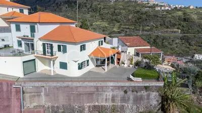 a large white house with an orange roof at Casa Vista Mar by GALMI in Calheta