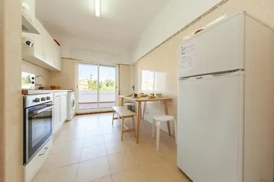 a kitchen with a white refrigerator and a table at B68 - Luz Vista Mar Apartment in Luz