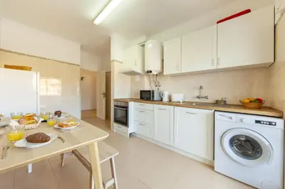 a kitchen with white cabinets and a table with food at B68 - Luz Vista Mar Apartment in Luz