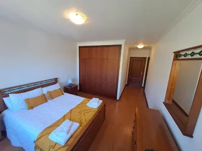 a bedroom with a large bed with two towels on it at Ocean Gardens in Caniço