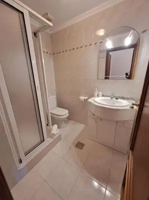 a bathroom with a sink and a toilet and a mirror at Ocean Gardens in Caniço