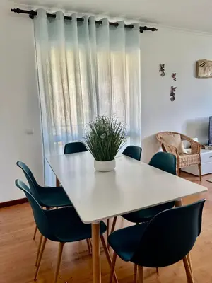 a dining room with a white table and blue chairs at Ocean Gardens in Caniço