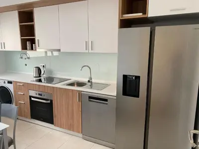 a kitchen with a stainless steel refrigerator and wooden cabinets at Paradise Garajau in Garajau